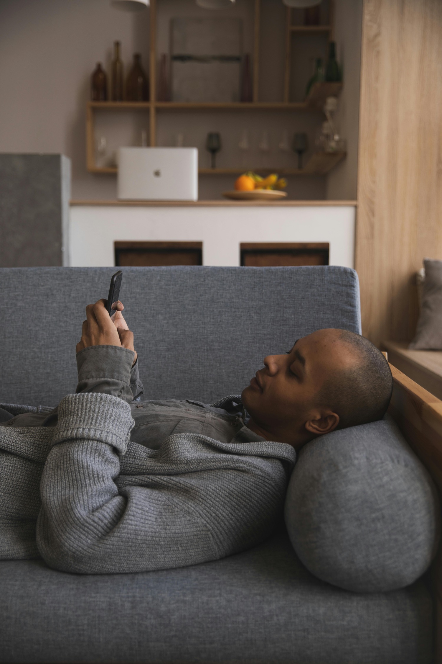 Somebody lying on a sofa reading an answer on their phone