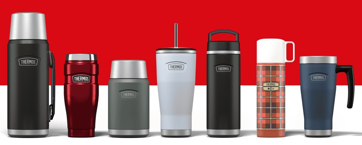 The Thermos line up photographed in a row on the brand's red, flasks, food jars, tumblers and a tartan vacuum flask