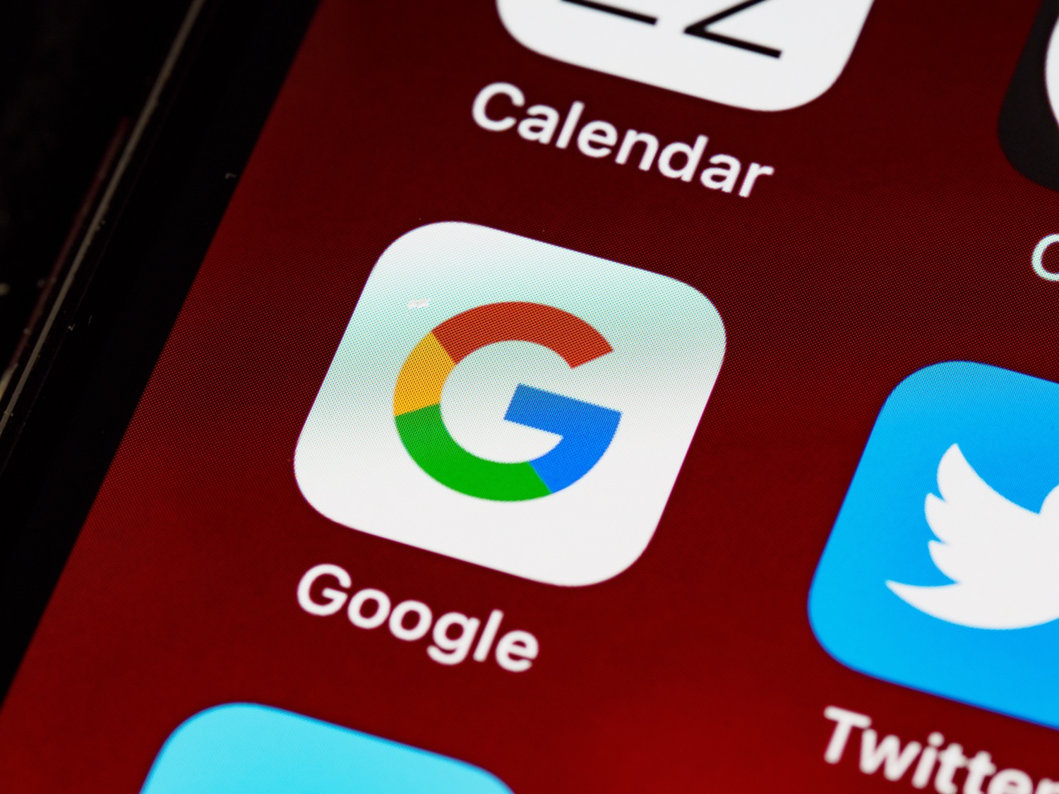 The Google app icon on a phone home screen beside the calendar and social apps